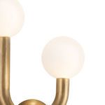 Close-up of second white globe with brass arm, emphasizing smooth matte glass and brushed metal finish
