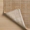 Back side of Judy Natural Cream Rug folded over to show woven backing and pattern consistency
