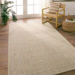 Latona rug styled in room with light wood floor, modern chair, and pouf