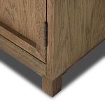 Close-up of metal hinge with rustic finish on side of cabinet door