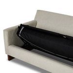 Detailed look at sleeper frame’s metal joint and fabric panel under sofa cushions