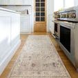 Runner rug placed in a bright kitchen with white cabinets and stainless steel stove, showing scale and room context