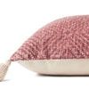 Side view showing pillow thickness and beige cotton backing with tassel detail