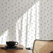Wallpaper applied on wall with light and shadow, showing dining table and woven chair in room setting