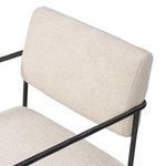 Close-up detail of plush cream bolster back and gently curved black iron armrest