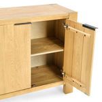 Open sideboard door with interior shelf and black metal hinges visible