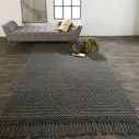 Rug styled in living room setting with chaise lounge and decorative pillows on dark wood floor