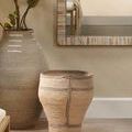 Trophy Basket placed on floor in styled room with large matching woven vase and mirror