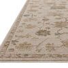 Willa Bone / Multi rug shown at an angle highlighting low pile texture and edge binding