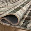 Close-up of Humphrey Forest rug corner lifted, revealing a dark gray woven underside