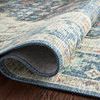Side view of rug edge curled up highlighting flexibility and layered color patterns on wood surface