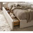 Close-up of open footboard storage drawer with pillows on drawer inside bed frame on textured rug