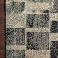 Detailed close-up of rug surface showing the contrast between beige and dark gray block patterns