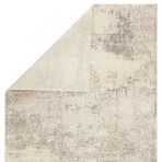 Top view of Brixt rug partially folded to reveal solid ivory backing