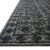 Low angled side view showing Cecelia rug's textured wool pile and edge binding
