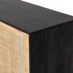 Close-up corner showing black mango wood top and cane door frame with grain detail