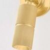 Truett Wall Sconce in aged brass with circular backplate, adjustable mechanical hinge, and fine knurling texture on cylind...