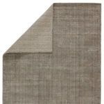 Top view of rug corner flipped over revealing reverse underside knit pattern in lighter taupe color