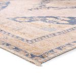 Close-up showing textured weave and edge details of tan and blue vintage medallion rug