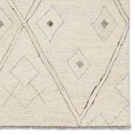 Zoomed detail of corner focusing on geometric diamond shapes and soft wool texture