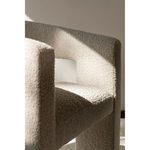 Close-up of Elo Chair seat and armrest with light and shadows enhancing boucle fabric texture