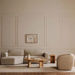 Madrid sectional styled in living room with neutral rug, wood coffee tables, and abstract wall art