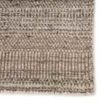 Macro detail of rug edge showcasing geometric pattern and tightly woven fibers