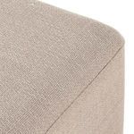 Corner close-up revealing parawood plinth base and tightly woven beige fabric