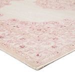 Close-up angled shot of rug corner highlighting intricately woven pink medallion border
