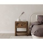 Rustic wooden nightstand with vase beside Colin bed with dark bedding against beige wall