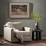 Hampton Swivel Chair styled in living room with throw draped over arm and framed artwork on wall
