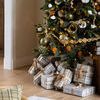 Olive green crackled glass ornaments hanging on decorated Christmas tree with plaid wrapped gifts beneath