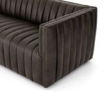 Angled close-up showing piping detail on armrest top edge and vertical channeling