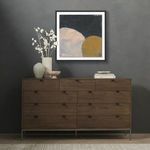 Painting hanging above modern wooden dresser with decor elements in a gray room