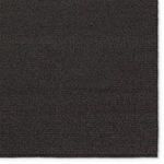Close-up showing textured diagonal weave pattern on the charcoal rug surface