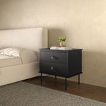 Side angled view of Reagan nightstand in bedroom setting with decorative items on top