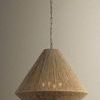 Keats pendant shown from a side view against a neutral wall, highlighting its natural woven texture