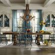 Set of Sanctuary Spindle Arm Chairs styled around large wooden dining table in farmhouse dining room with blue curtains