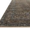 Close-up angled view showing the rug’s low pile texture and detailed woven border