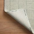 Corner of Francis Silver / Sky Rug flipped to show branded fabric backing with Chris Loves Julia x Loloi text