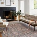 Rosemarie rug styled in bright living room with beige sofa and armchair by black fireplace