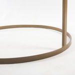 Close-up of circular bronze metal base showing matte finish and slight texture