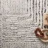 Close-up of rug with decorative tray and book on top, showing soft texture and pattern detail
