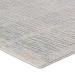 Close-up corner view showing soft pile texture and edge stitching of light gray and blue striped rug