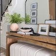Table adorned with greenery, books, decorative beads, placed near a staircase