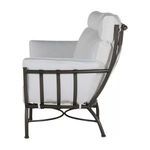 Side profile highlighting thick cushioned armrest and headrest with metal frame details