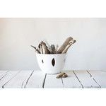 Bowl filled with driftwood on white wood plank surface for rustic look