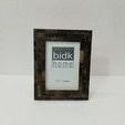 Black Horn Step Design Picture Frame against plain light-textured wall on flat surface