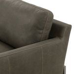 Close-up on the sofa's arm and back cushions showing soft leather detail and stitching