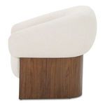 Side view of Otto accent chair highlighting rounded upholstered back and wood grain of walnut base